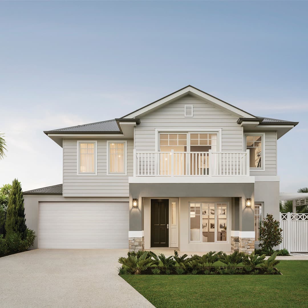 Contemporary two-story house with gray siding, white balcony, black front door, and double garage.